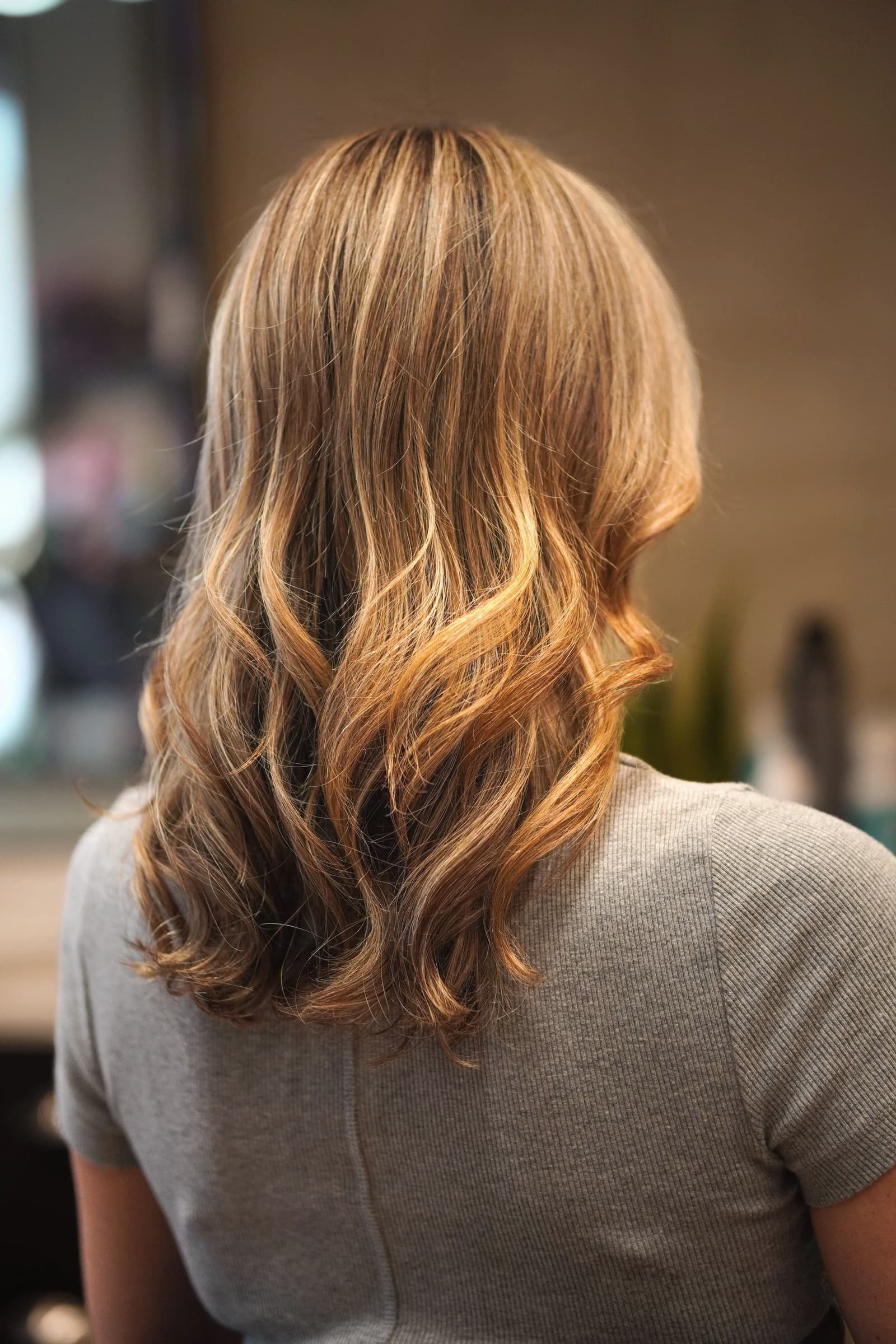 A finished blow-dry in a hair salon, seen from behind.